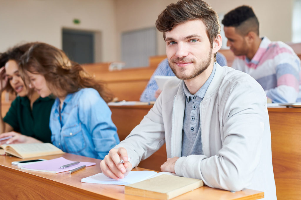 Portrait of college student sitting at desk during a lesson